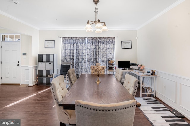 dining area with a wainscoted wall, crown molding, a notable chandelier, and wood finished floors