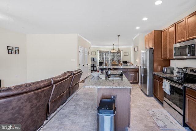 kitchen featuring an island with sink, light stone counters, open floor plan, stainless steel appliances, and a sink