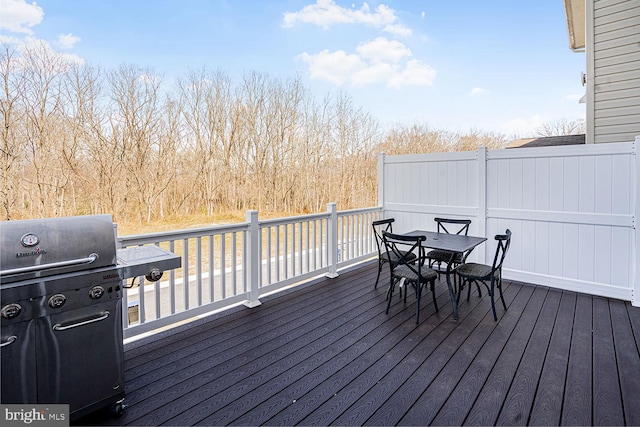 wooden deck featuring outdoor dining space and a grill