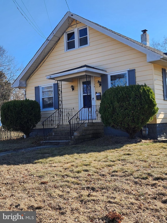 bungalow-style home featuring a front lawn