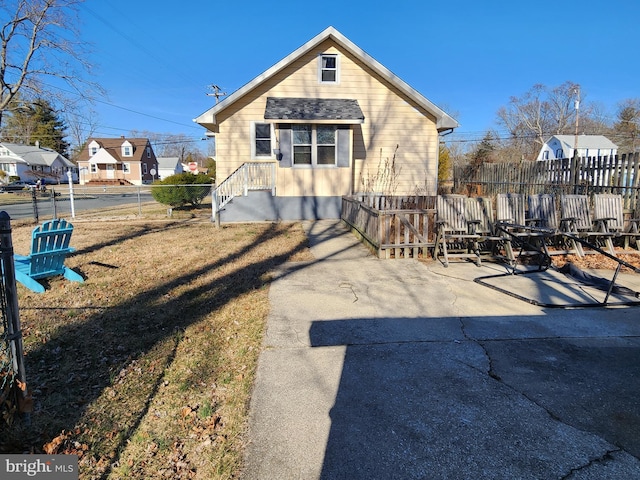 back of house with fence and a lawn