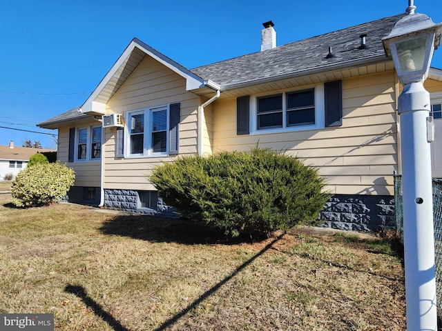 view of home's exterior with roof with shingles, a lawn, and a chimney