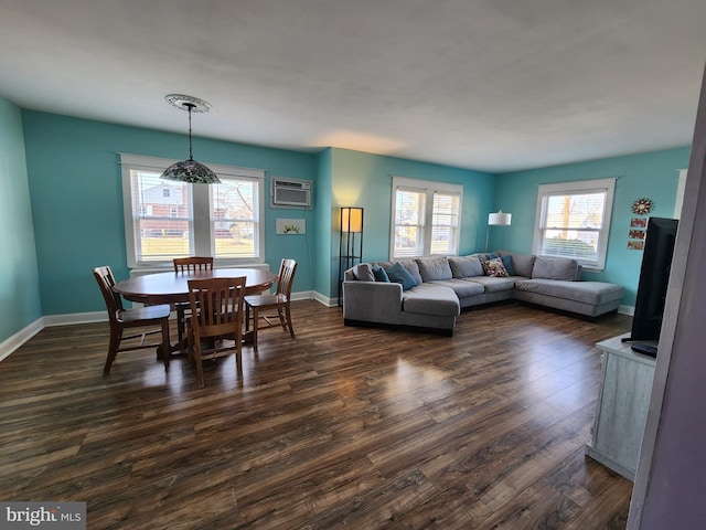 dining space with a wall mounted AC, dark wood finished floors, and baseboards