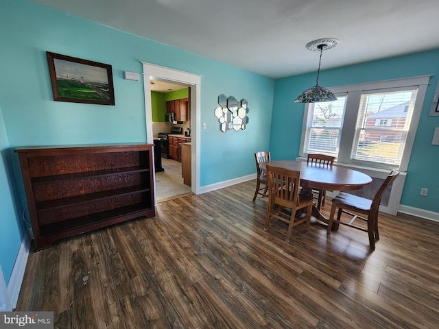 dining area featuring baseboards and wood finished floors