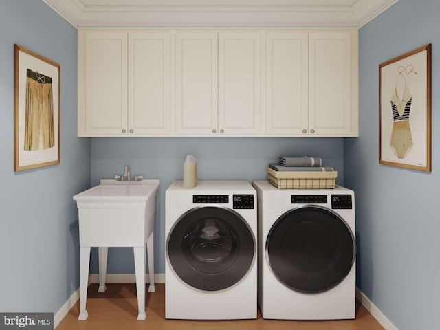 laundry room with cabinet space, baseboards, light wood finished floors, and washer and dryer