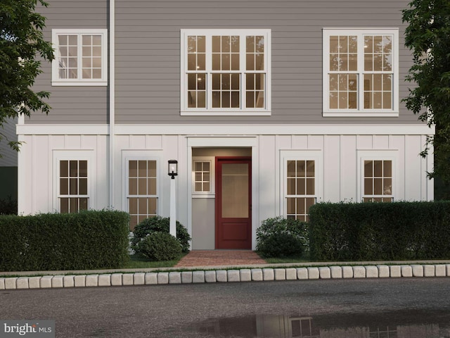 doorway to property with board and batten siding and visible vents