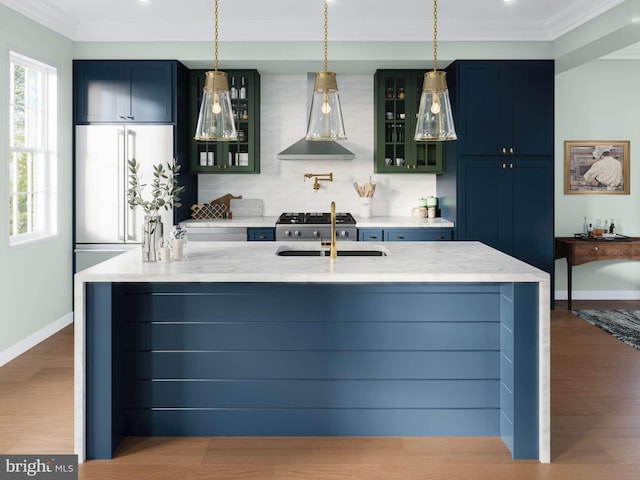 kitchen with crown molding, high quality fridge, a sink, and wood finished floors