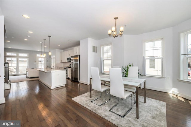 dining space featuring dark wood finished floors, a healthy amount of sunlight, and visible vents