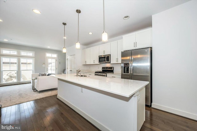 kitchen with white cabinets, stainless steel appliances, dark wood-type flooring, and a sink