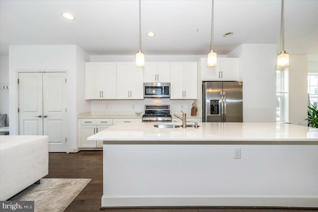 kitchen featuring a sink, stainless steel appliances, dark wood-style floors, and white cabinetry