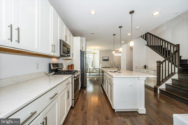 kitchen with dark wood-style floors, white cabinets, stainless steel appliances, and a sink