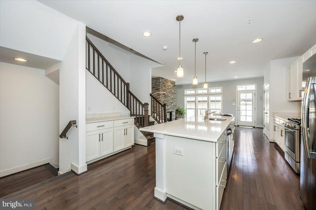 kitchen with dark wood-type flooring, white cabinets, stainless steel gas range, and light countertops