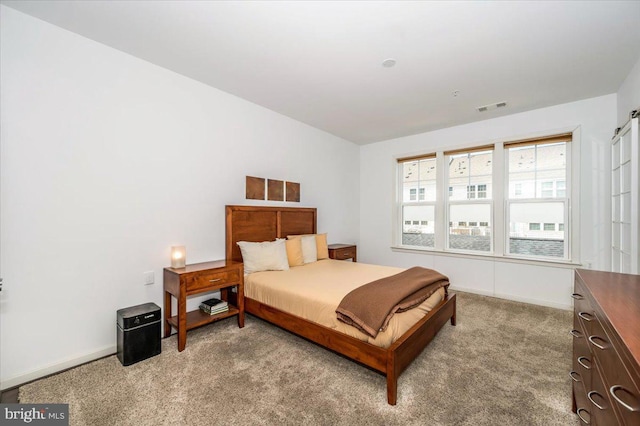 carpeted bedroom featuring visible vents and baseboards