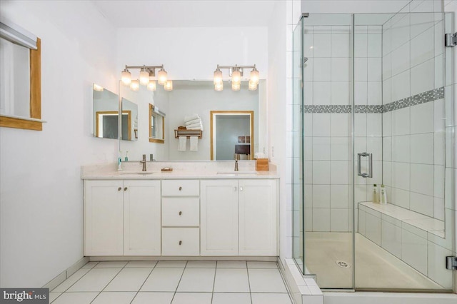 full bath with tile patterned floors, double vanity, a stall shower, and a sink