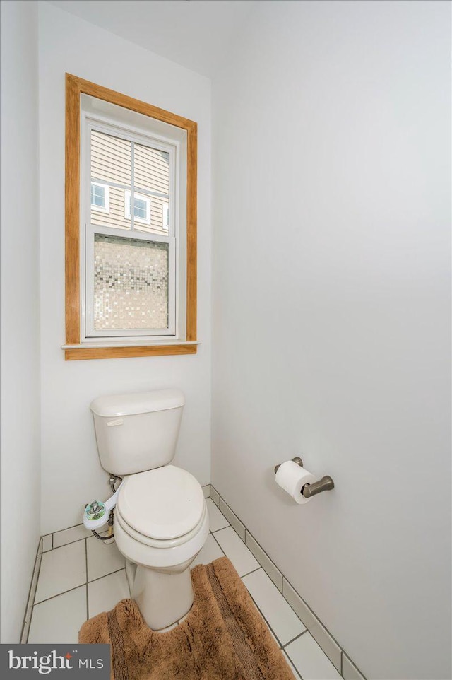 bathroom with tile patterned flooring, toilet, and baseboards