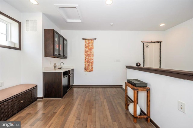 interior space featuring visible vents, hardwood / wood-style flooring, a sink, recessed lighting, and wet bar