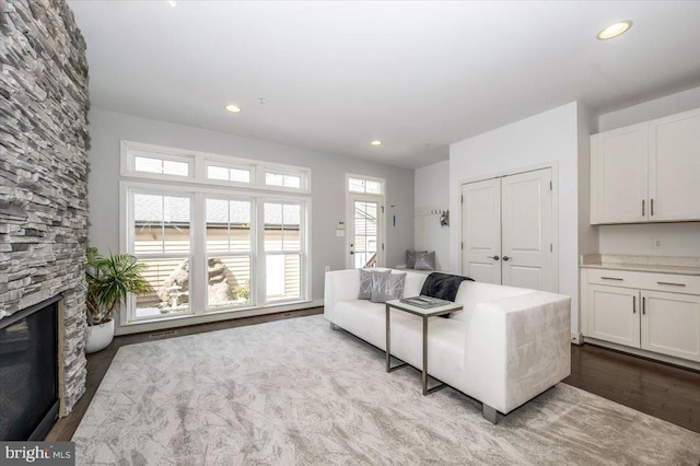 living area with recessed lighting, wood finished floors, and a fireplace