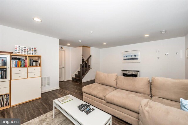 living area featuring stairs, dark wood-type flooring, recessed lighting, and visible vents