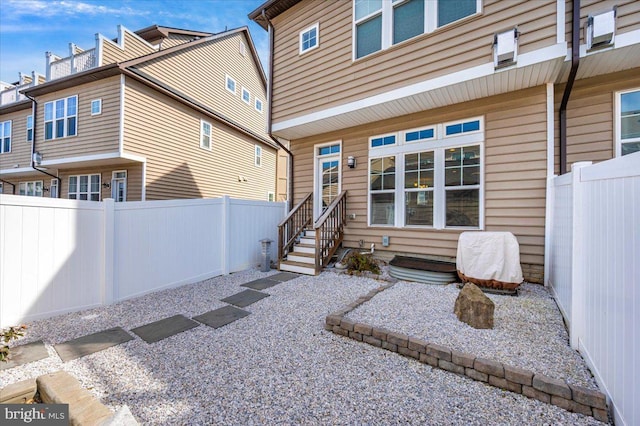 back of house with entry steps and a fenced backyard