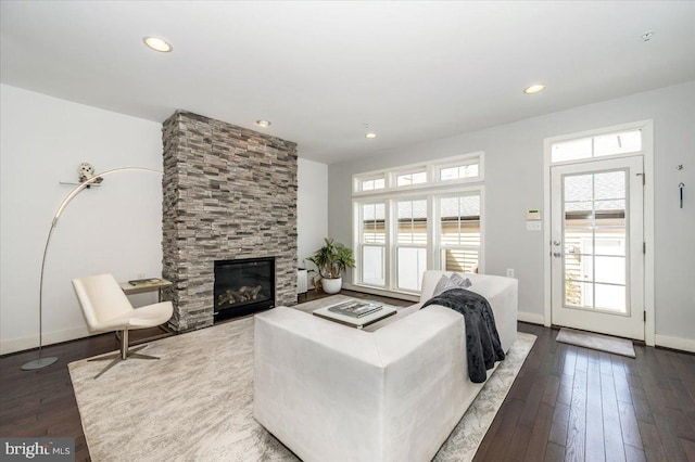 living room featuring recessed lighting, baseboards, hardwood / wood-style floors, and a fireplace