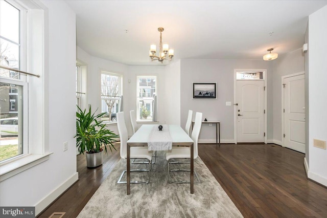 dining room featuring a chandelier, dark wood-type flooring, and baseboards