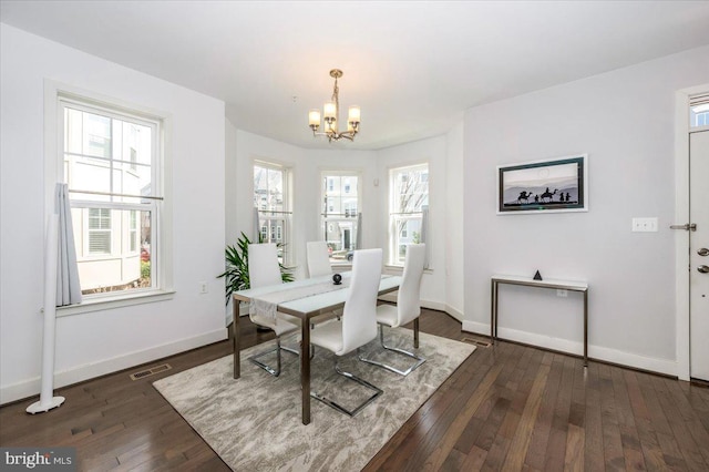 dining area with an inviting chandelier, baseboards, visible vents, and dark wood-style flooring