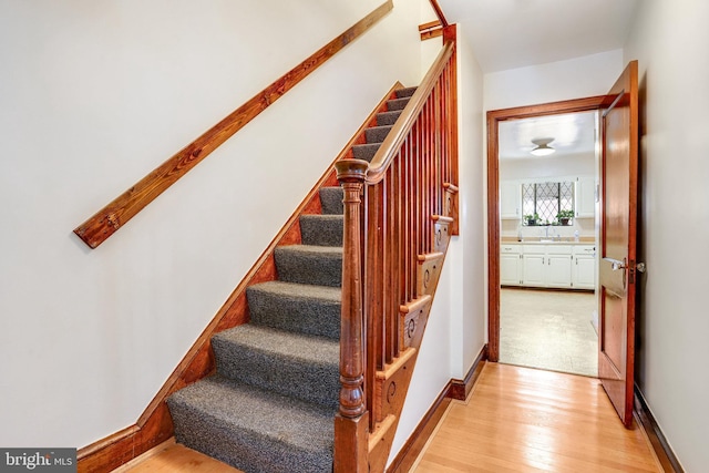 staircase with wood finished floors and baseboards