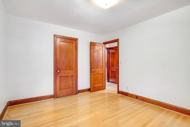 unfurnished bedroom featuring light wood-type flooring and baseboards