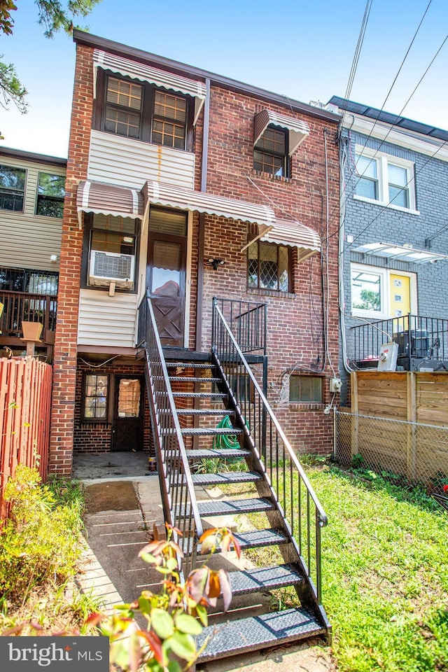 view of front of property with brick siding and fence