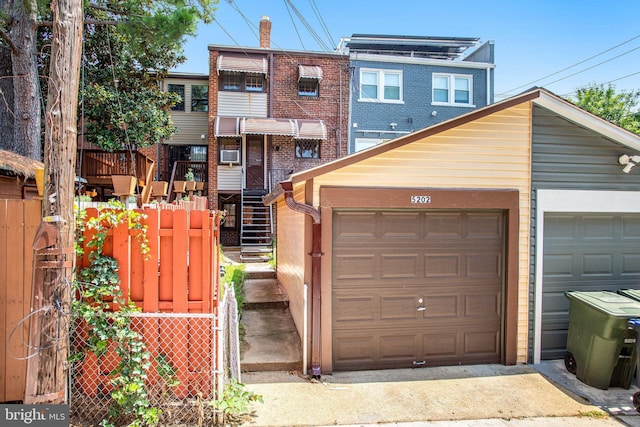 townhome / multi-family property featuring a garage and fence