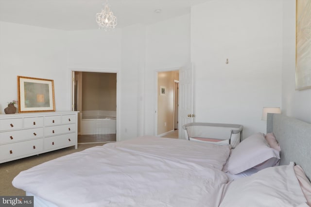 bedroom featuring a high ceiling, carpet, an inviting chandelier, and ensuite bath