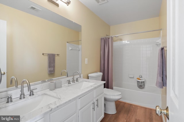 full bath with a sink, visible vents, toilet, and wood finished floors