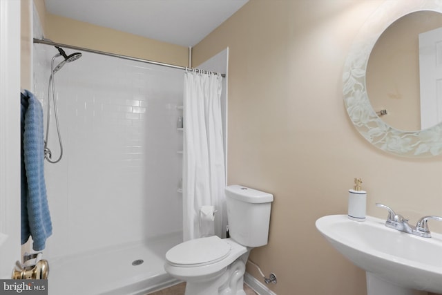 bathroom with a sink, toilet, and a shower stall