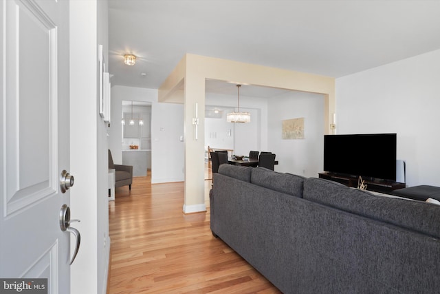 living area with a chandelier and light wood-style floors