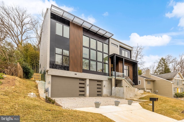 view of front of home with an attached garage, driveway, and stairway