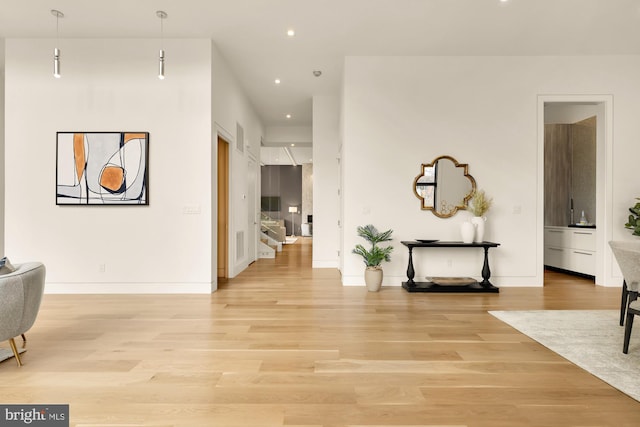 corridor featuring stairway, light wood-style flooring, baseboards, and recessed lighting