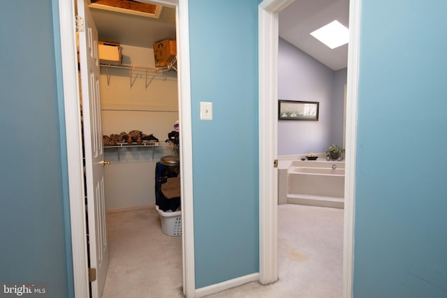 interior space with vaulted ceiling, carpet floors, and baseboards