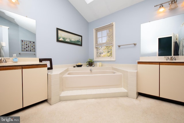 full bathroom featuring vaulted ceiling, a sink, two vanities, and a bath