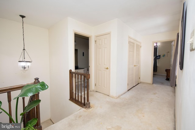 hall with carpet and an upstairs landing