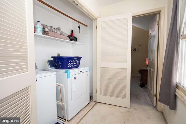 washroom with laundry area, washing machine and dryer, and light colored carpet