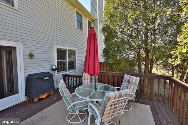 deck with outdoor dining area and a grill