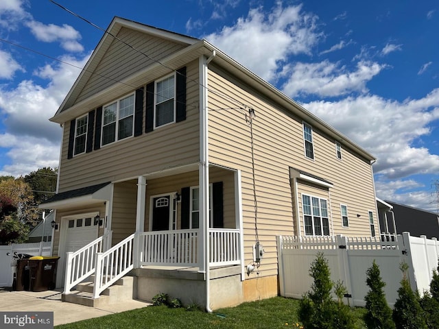 view of property exterior featuring covered porch, fence, and a garage