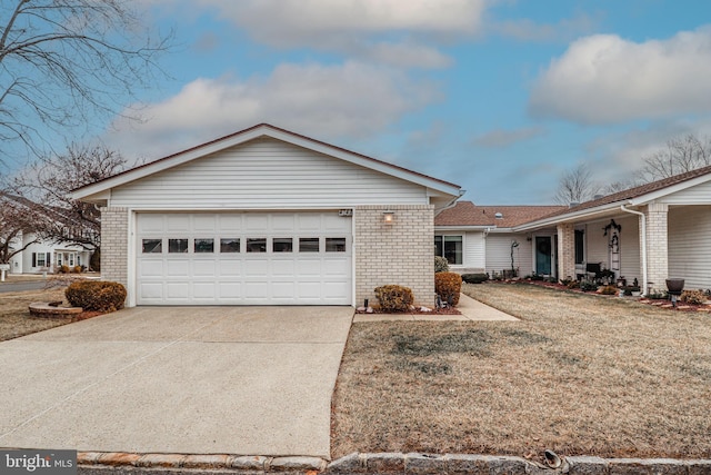 single story home with a front yard, concrete driveway, brick siding, and an attached garage