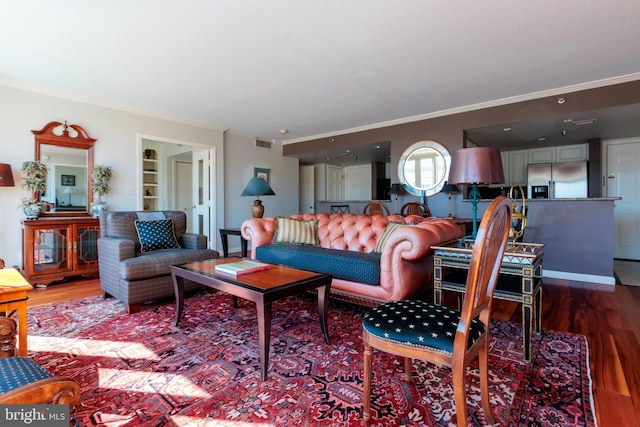 living room featuring wood finished floors, visible vents, and crown molding