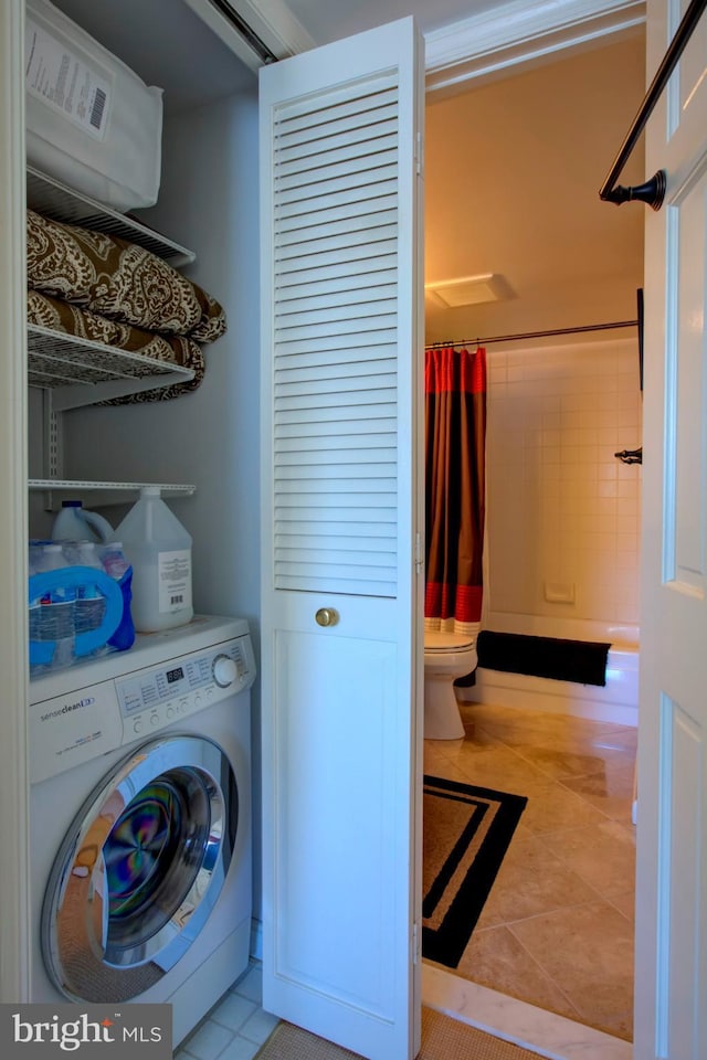 clothes washing area with laundry area, tile patterned flooring, and washer / dryer