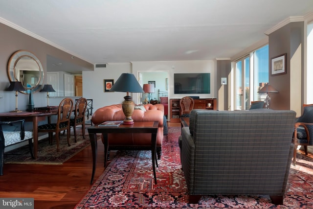 living room featuring visible vents, ornamental molding, and wood finished floors