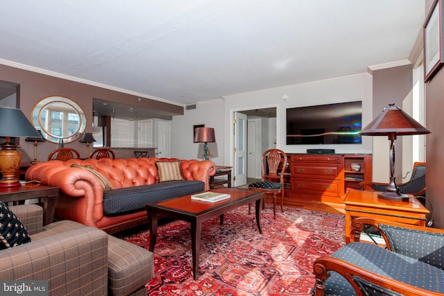 living room with baseboards, crown molding, visible vents, and wood finished floors