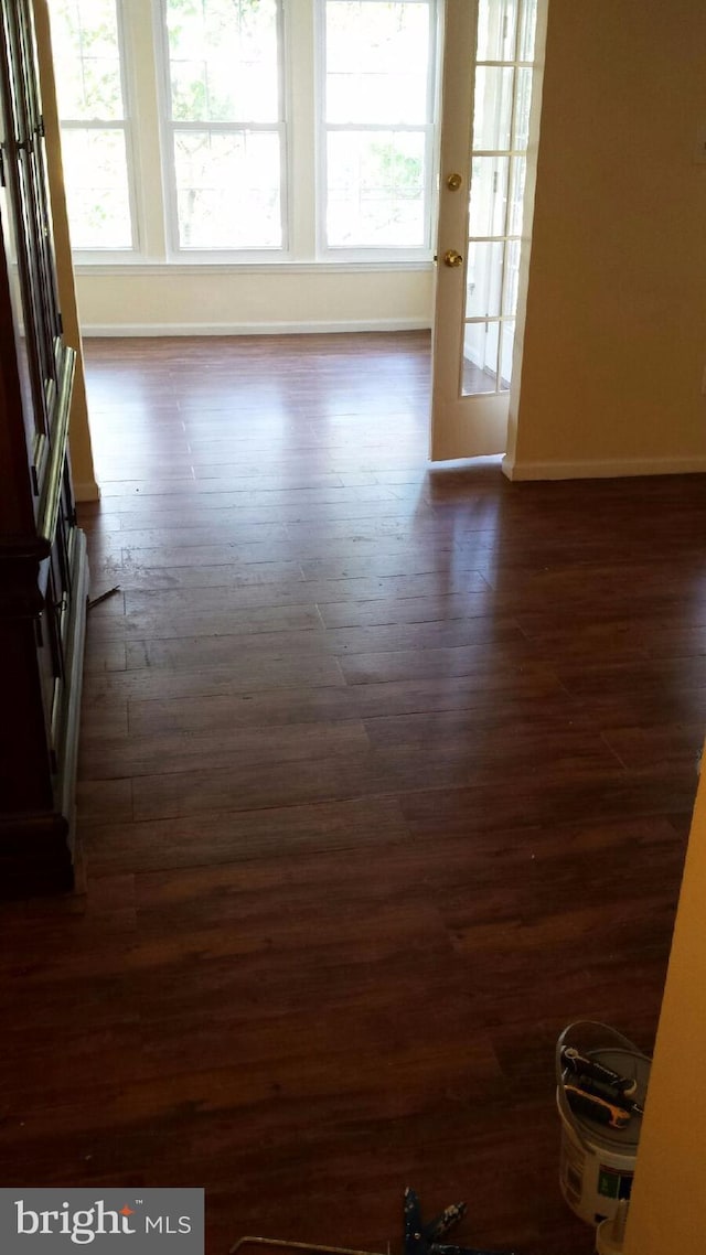 spare room featuring dark wood-style flooring and baseboards