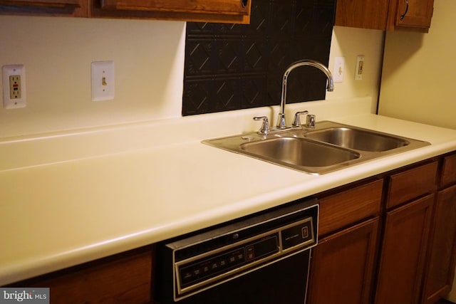 kitchen with dishwasher, light countertops, and a sink