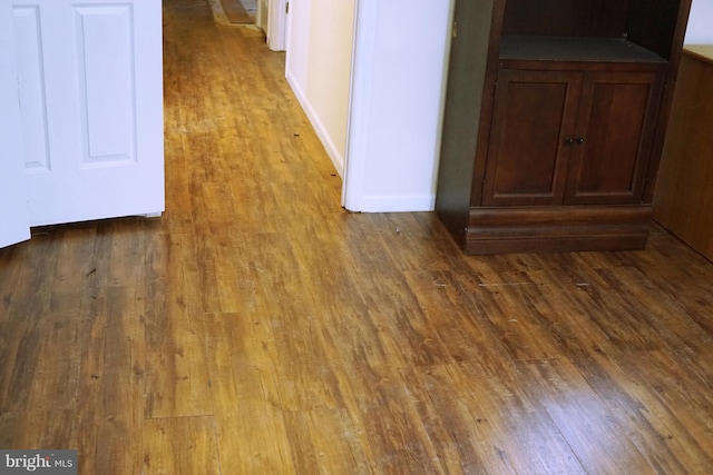 interior space featuring baseboards and wood finished floors